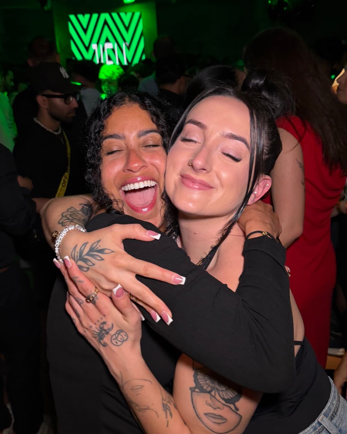 Miranda hugging a community member at an evening event